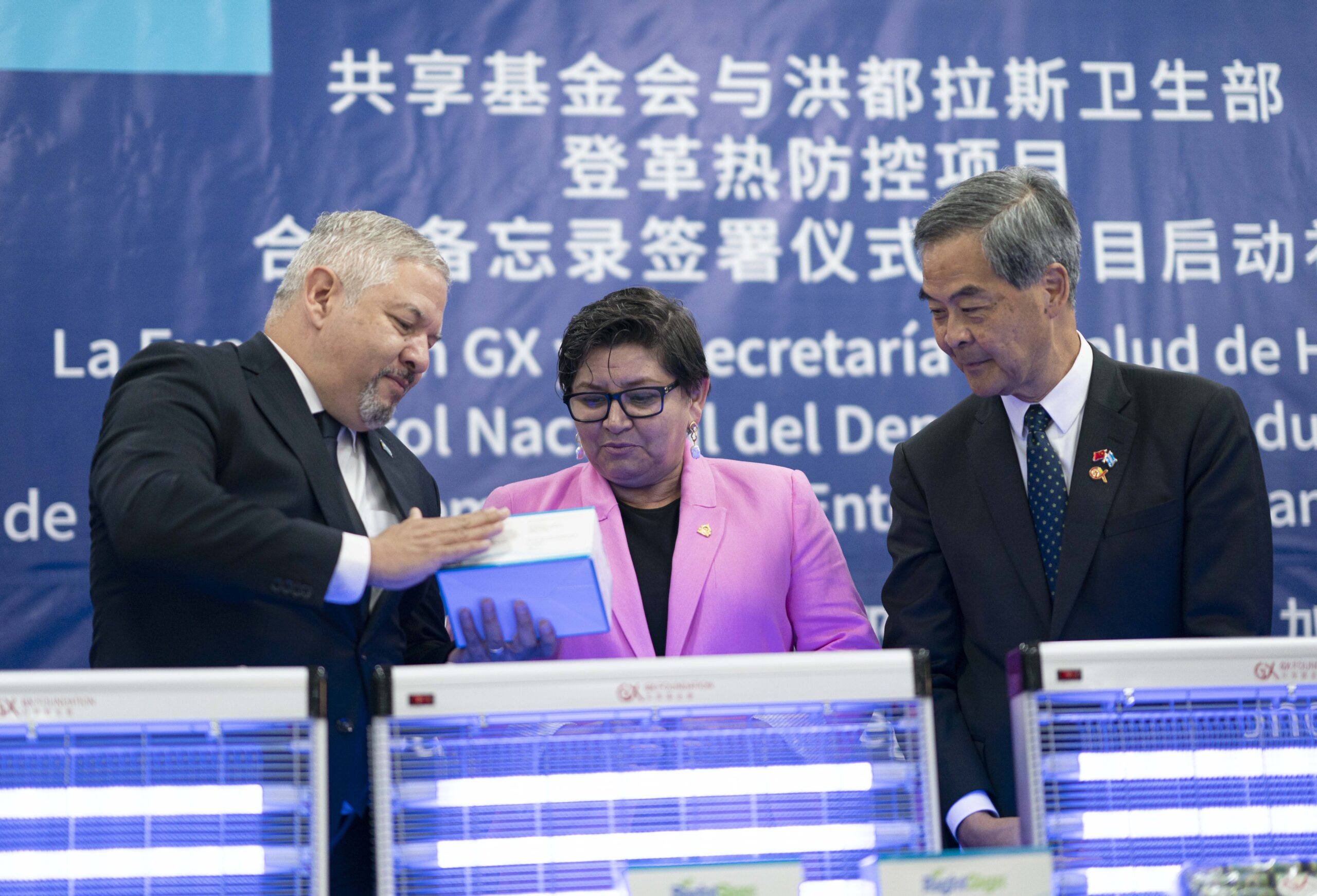 Presidente de la Fundación GX, Leung Chun-ying (d), la ministra de Salud hondureña, Carla Paredes (c), y el canciller de Honduras, Enrique Reina (i), participando en la firma del Memorándum de Entendimiento para Control Nacional del Dengue entre la Secretaría de Salud de Honduras y la Fundación GX, en Tegucigalpa, Honduras.